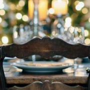 empty dining chair at a table with holiday decorations in the background