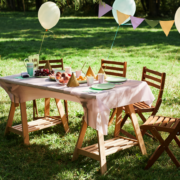 empty table set up for a party outside in a garden in midday