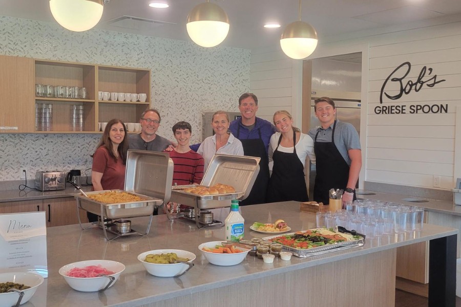 Brian and Dr. Brook Griese and Family serving dinner, smiling
