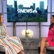 image of two women, both wearing dresses, sitting down across from one another for an interview